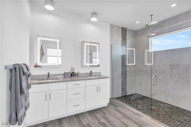 bathroom featuring a shower with door, vanity, and wood-type flooring