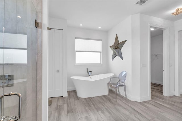 bathroom with plus walk in shower and hardwood / wood-style floors