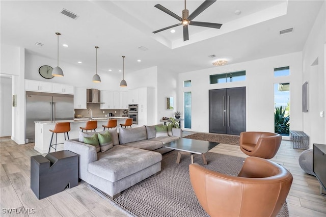 living room featuring sink, a towering ceiling, and ceiling fan