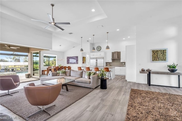 living room featuring ceiling fan and a high ceiling