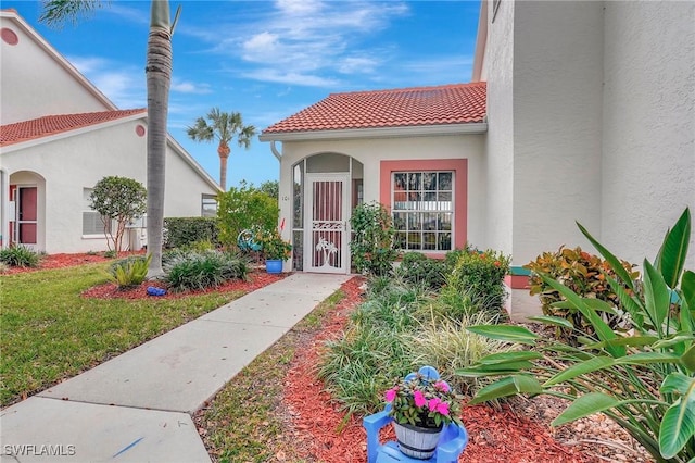 entrance to property with a lawn