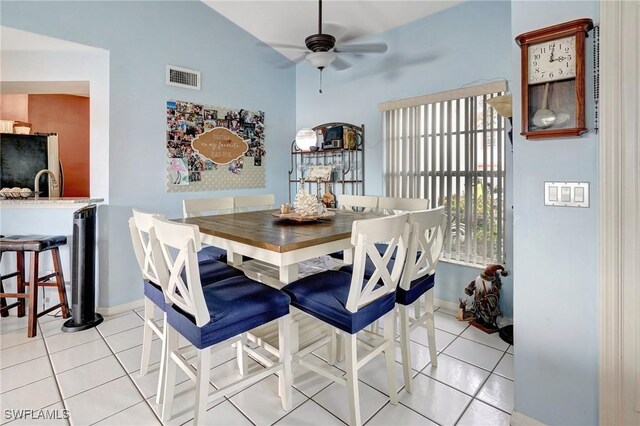 dining room with ceiling fan, light tile patterned flooring, and lofted ceiling