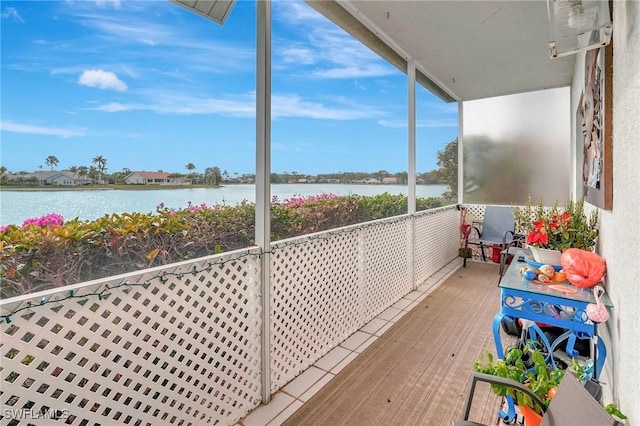 sunroom featuring a water view