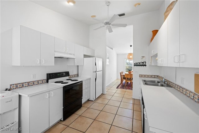 kitchen featuring white refrigerator, electric range oven, white cabinetry, and light tile patterned floors