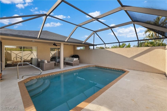 view of swimming pool with ceiling fan, a lanai, an outdoor living space, and a patio area