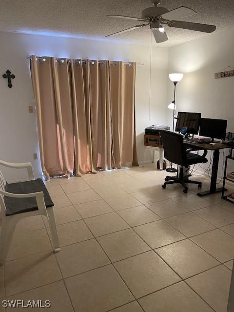 office area with a textured ceiling, ceiling fan, and light tile patterned floors