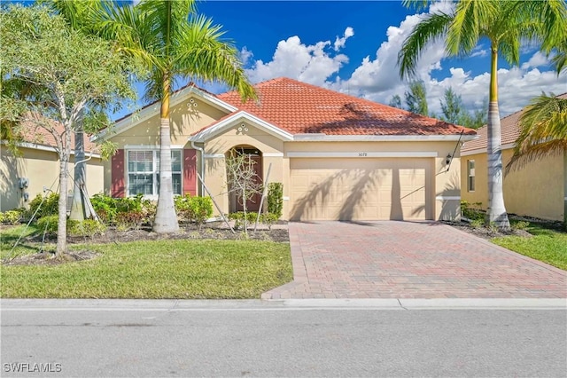 mediterranean / spanish home featuring a front lawn and a garage