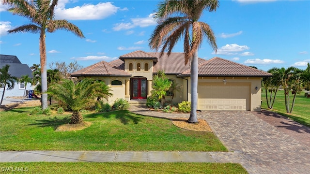 mediterranean / spanish house featuring a front lawn and a garage