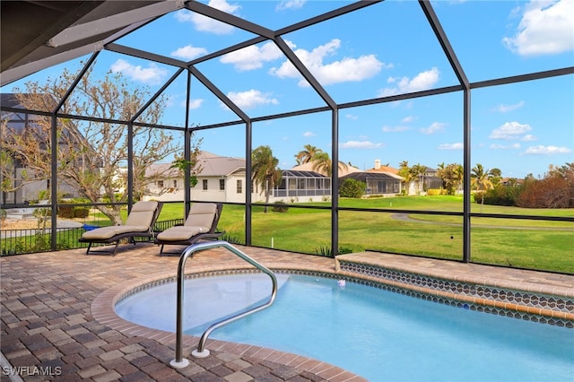 view of pool featuring a yard, glass enclosure, and a patio area