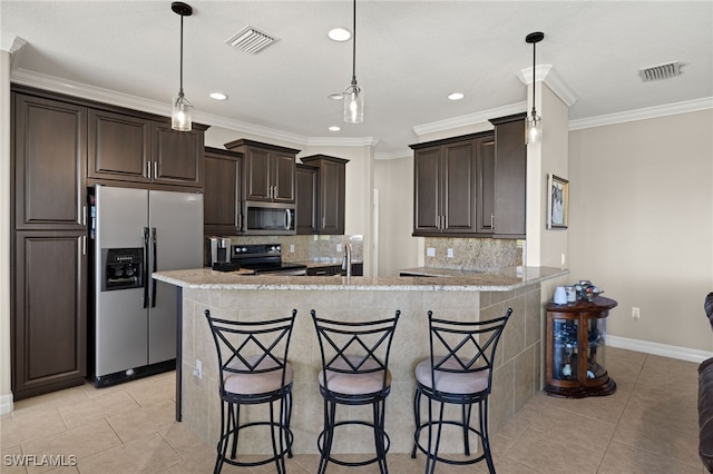 kitchen with a breakfast bar area, decorative backsplash, kitchen peninsula, and appliances with stainless steel finishes