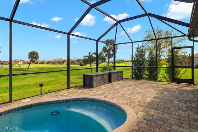 view of pool with a patio, glass enclosure, and a lawn