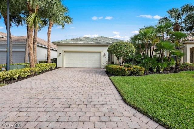 view of front of home with a garage and a front lawn