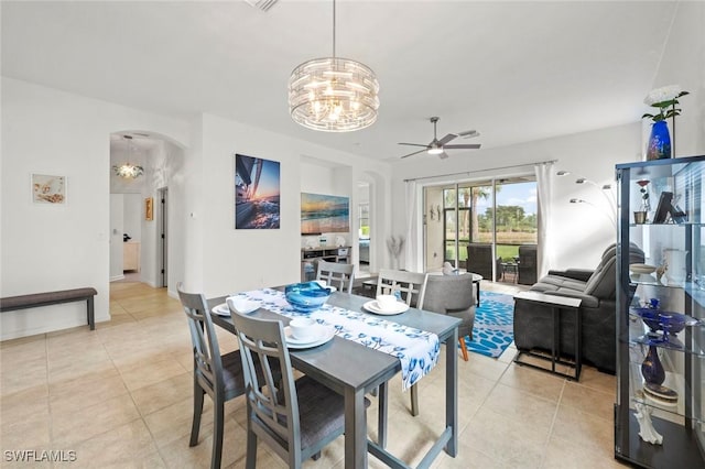 dining room featuring ceiling fan with notable chandelier and light tile patterned flooring