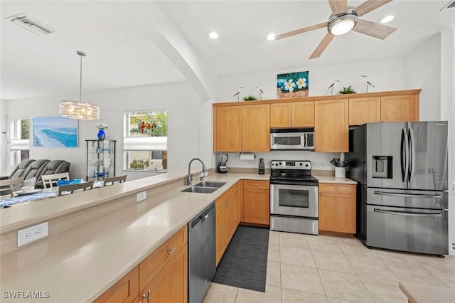 kitchen featuring ceiling fan with notable chandelier, stainless steel appliances, sink, hanging light fixtures, and light tile patterned floors