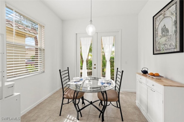 dining area with plenty of natural light, light tile patterned floors, and french doors