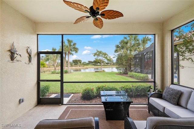 sunroom with a water view, a healthy amount of sunlight, and ceiling fan