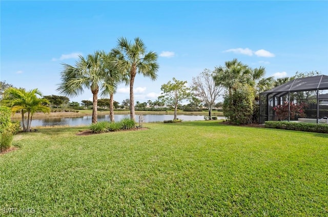 view of yard with glass enclosure and a water view