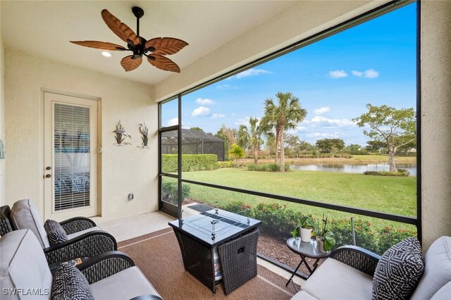 sunroom featuring a water view and ceiling fan