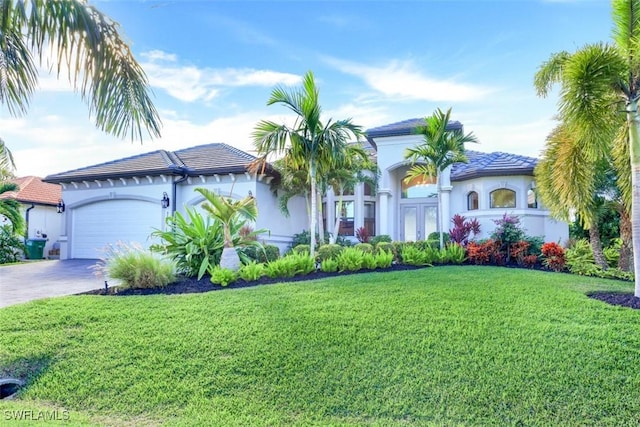 mediterranean / spanish-style home featuring a front yard and a garage