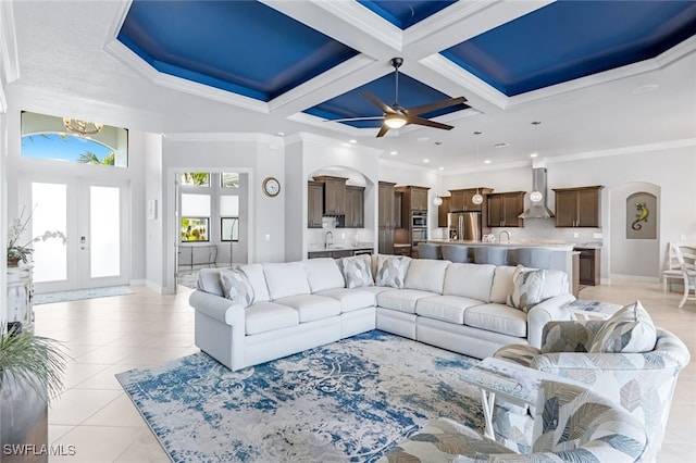 tiled living room featuring coffered ceiling, french doors, crown molding, and beam ceiling