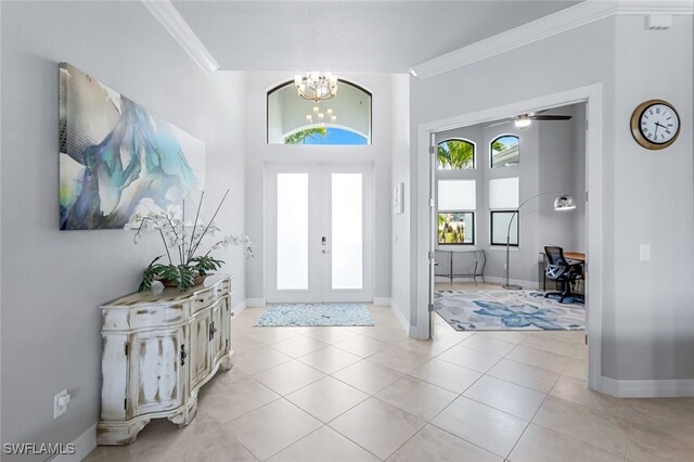 entryway featuring french doors, a chandelier, light tile patterned floors, and crown molding