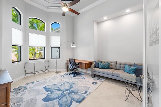 living room featuring ornamental molding, ceiling fan, and a towering ceiling