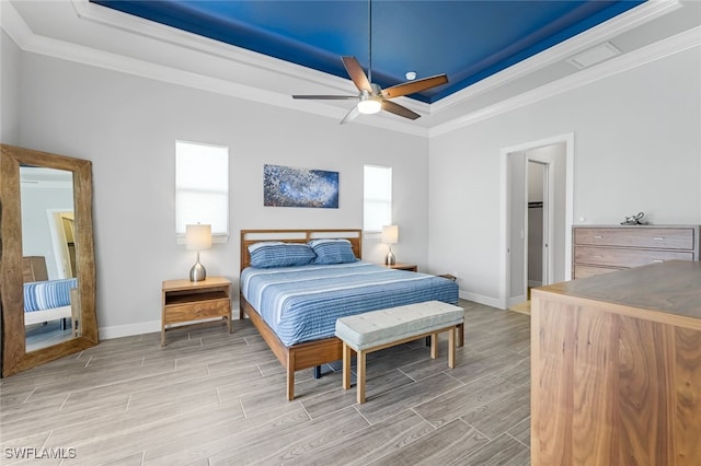 bedroom featuring ornamental molding, ceiling fan, and a tray ceiling