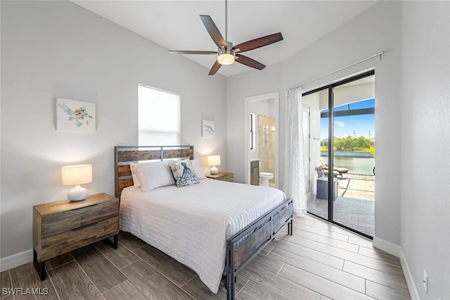 bedroom featuring access to outside, ensuite bathroom, ceiling fan, and a water view