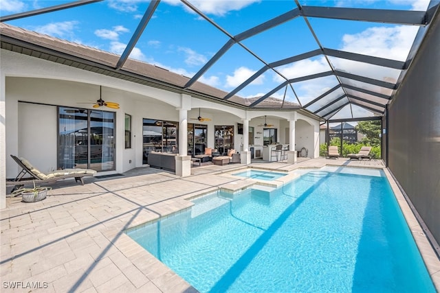 view of swimming pool featuring ceiling fan, a patio, glass enclosure, and an in ground hot tub