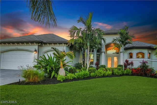 mediterranean / spanish-style house with french doors, a yard, and a garage