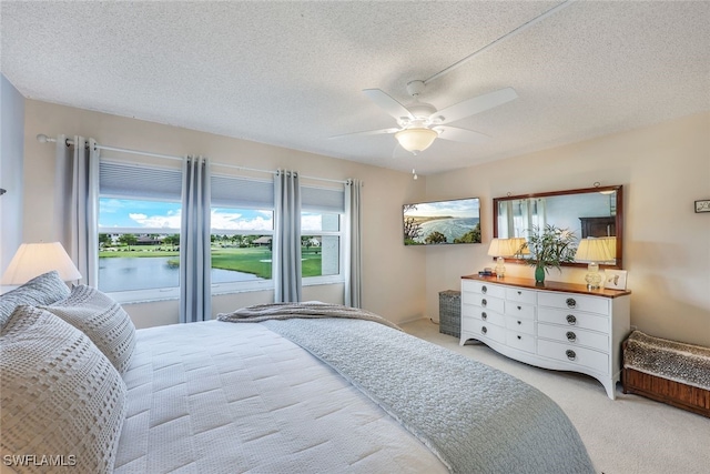 carpeted bedroom with multiple windows, a textured ceiling, and ceiling fan