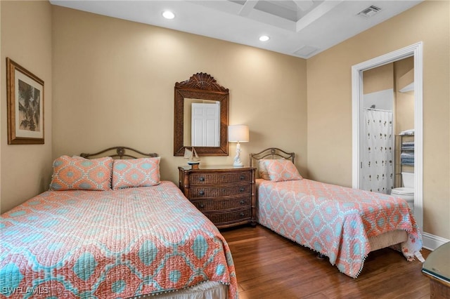 bedroom featuring ensuite bathroom and dark wood-type flooring