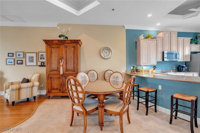 dining space featuring light tile patterned floors and crown molding