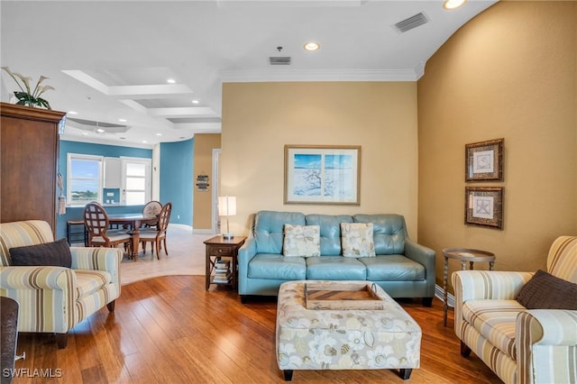 living room with ornamental molding, beam ceiling, and light hardwood / wood-style flooring