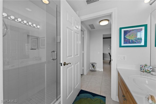 bathroom with a shower with door, tile patterned floors, and vanity