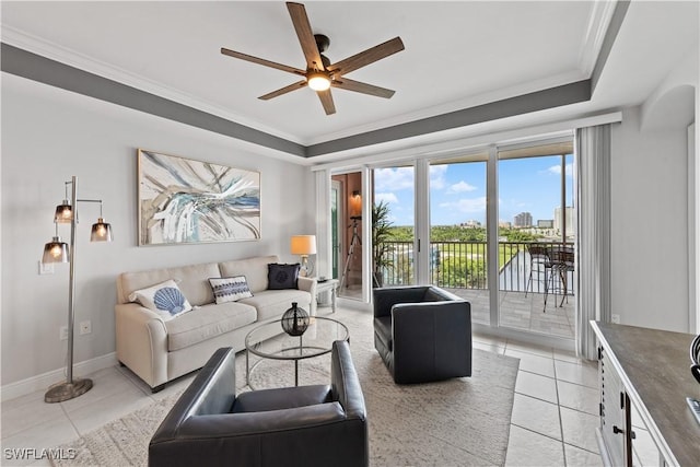 tiled living room featuring ornamental molding, ceiling fan, and a tray ceiling