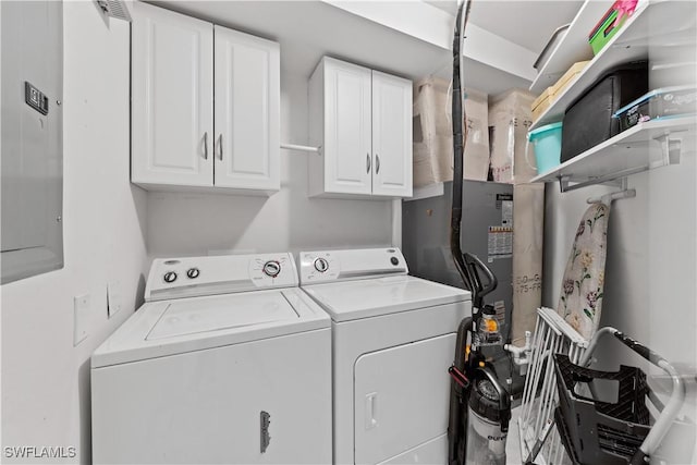 clothes washing area featuring separate washer and dryer and cabinets