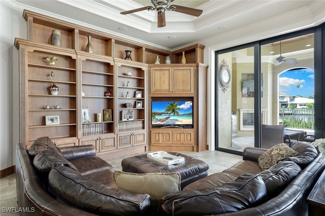 living room featuring ornamental molding, ceiling fan, a tray ceiling, and light tile patterned floors