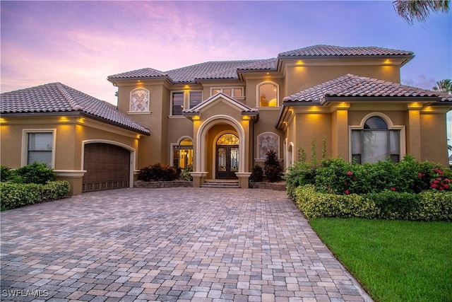 mediterranean / spanish house with french doors and a garage