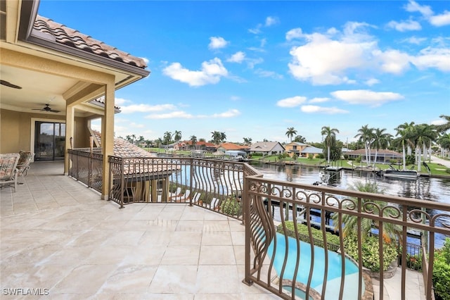 balcony featuring ceiling fan and a water view