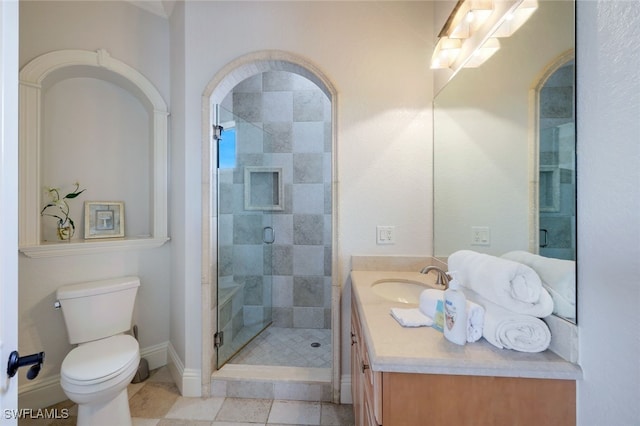 bathroom featuring toilet, tile patterned floors, a shower with shower door, and vanity