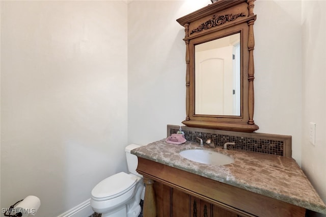 bathroom with toilet, tasteful backsplash, and vanity