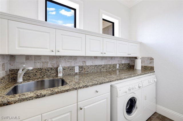 clothes washing area with independent washer and dryer, cabinets, and sink