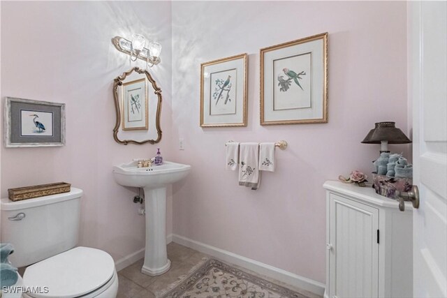 bathroom with toilet and tile patterned flooring