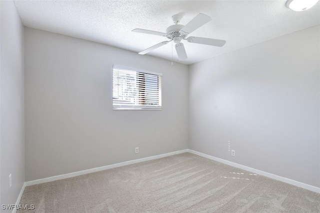 spare room with light carpet, ceiling fan, and a textured ceiling