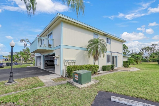 view of property exterior with a balcony, a yard, and a garage