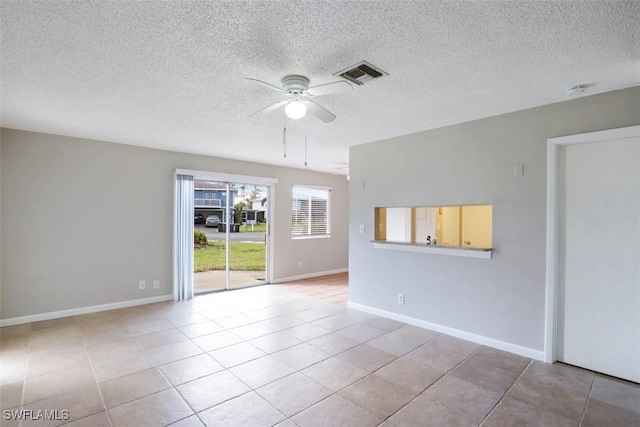 unfurnished room featuring a textured ceiling, ceiling fan, and light tile patterned floors