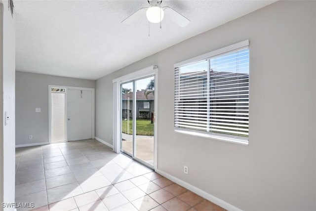 tiled spare room featuring ceiling fan