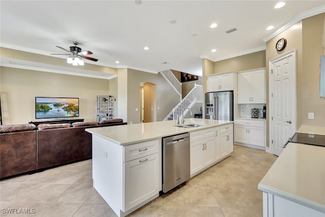 kitchen with white cabinetry, stainless steel appliances, and a center island with sink