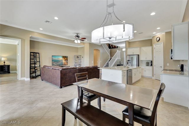 dining space featuring ceiling fan, light tile patterned floors, and crown molding